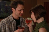 Man and woman drink cocktails in motel room